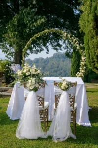 Tavolo degli sposi allestito sotto un arco floreale all'aperto, matrimonio in Italia