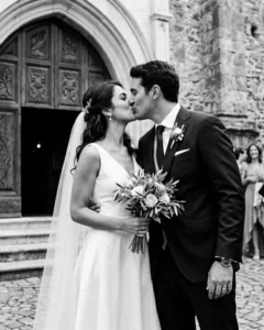 Gli sposi si baciano davanti al portale della chiesa dopo la cerimonia, matrimonio in Italia